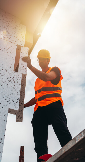 Worker installing a roof or insulation panel against a bright sky